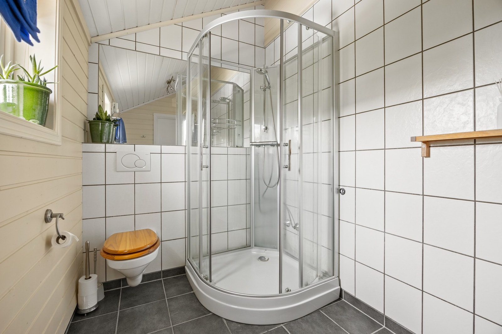 Badet er utstyrt med servantskap, dusjkabinett og toalett Galleribilde