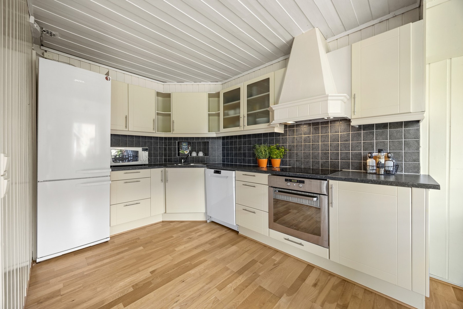 Pen kjøkkeninnredning med integrert stekeovn og platetopp, det er også avsatt plass for oppvaskmaskin og kjøleskap Galleribilde