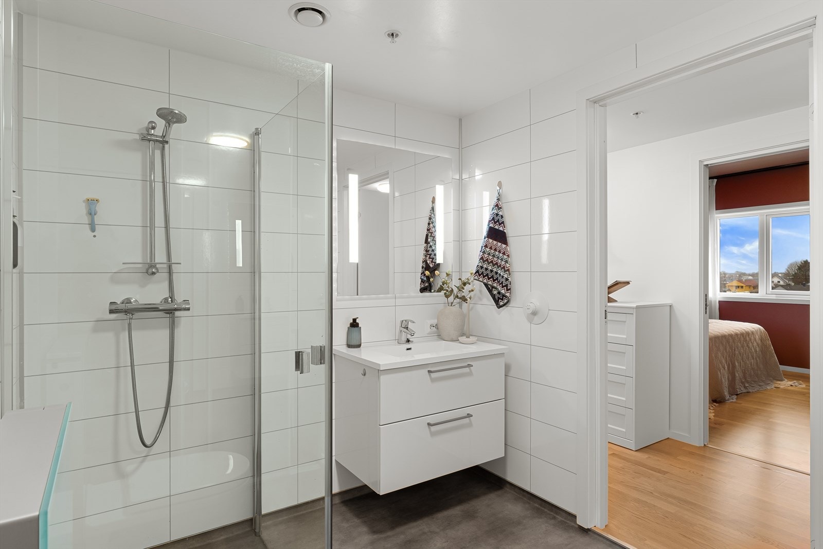 Lyst og fint bad med belegg på gulv og baderomsplater på vegg. Praktisk. Galleribilde