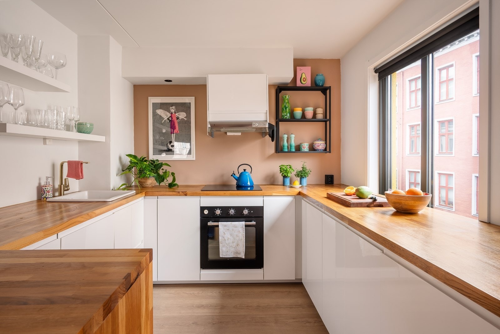 Det delikate kjøkkenet er innredet med slette, hvite fronter og benkeplate i tre. Galleribilde