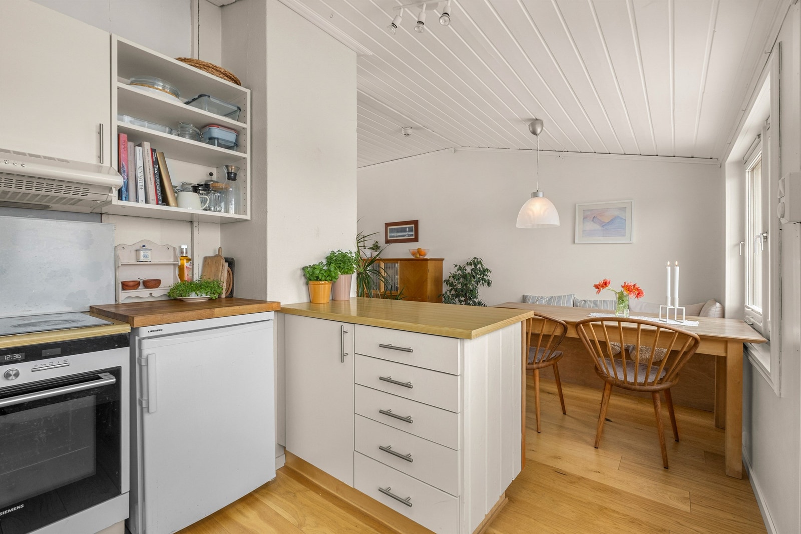 Kjøkkenet ligger naturlig tilbaketrukket fra stuen og er innredet med lyse slette flater og benkeplate med laminert overflate. Galleribilde