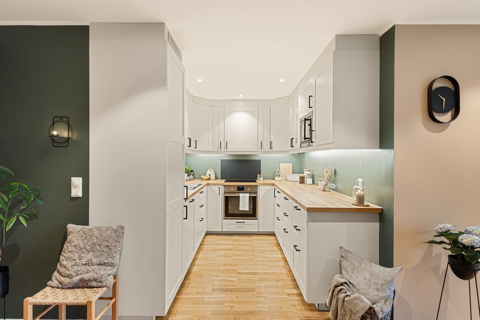 Kjøkkenet ble installert i 2016/2017 og har en stilren innredning med profilerte, hvite fronter og benkeplate i heltre. Galleribilde