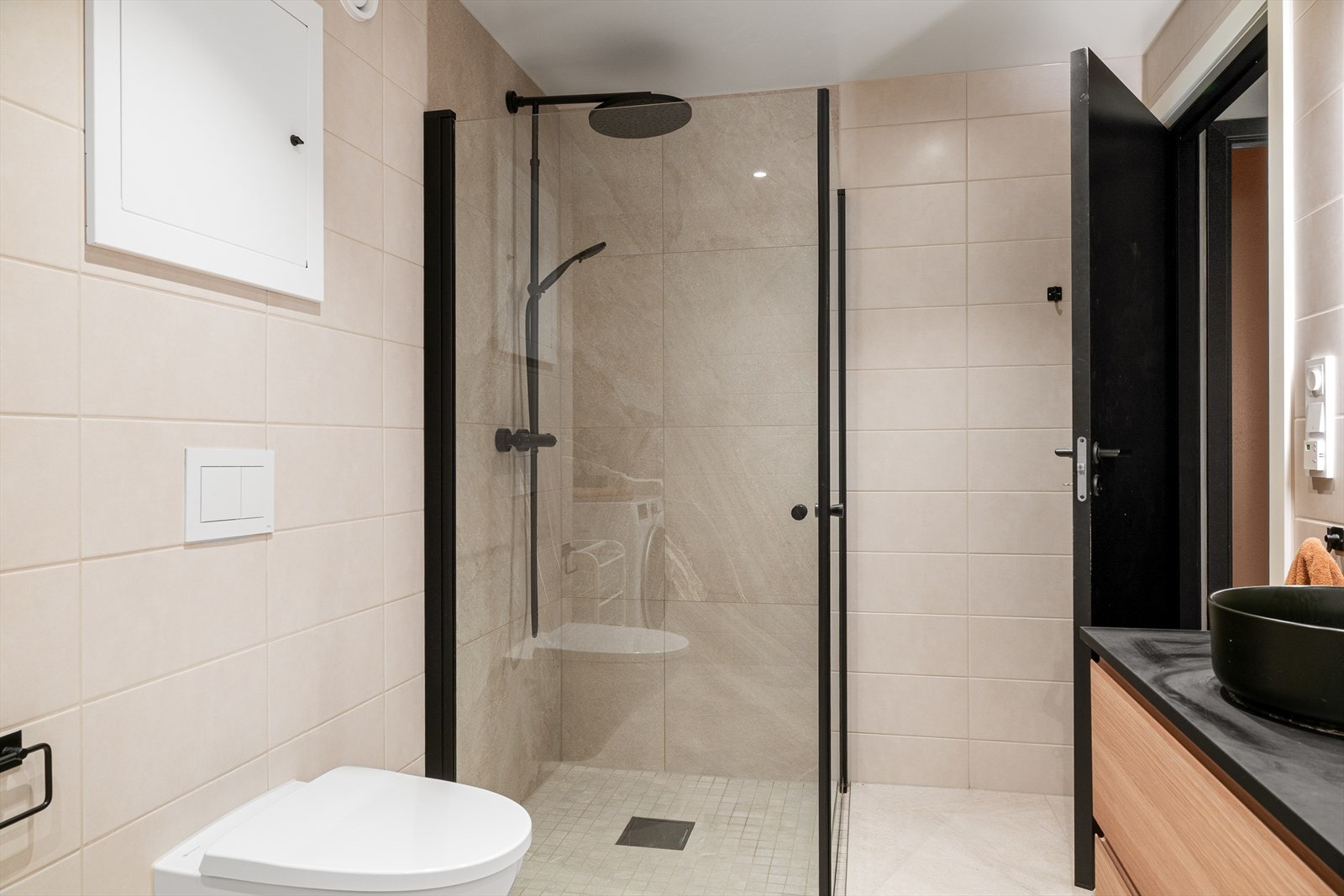 Det er innredet med vegghengt toalett, dusjhjørne, vask i seksjon med skuffeplass, speil med belysning, samt opplegg for vaskemaskin og tørketrommel. Galleribilde