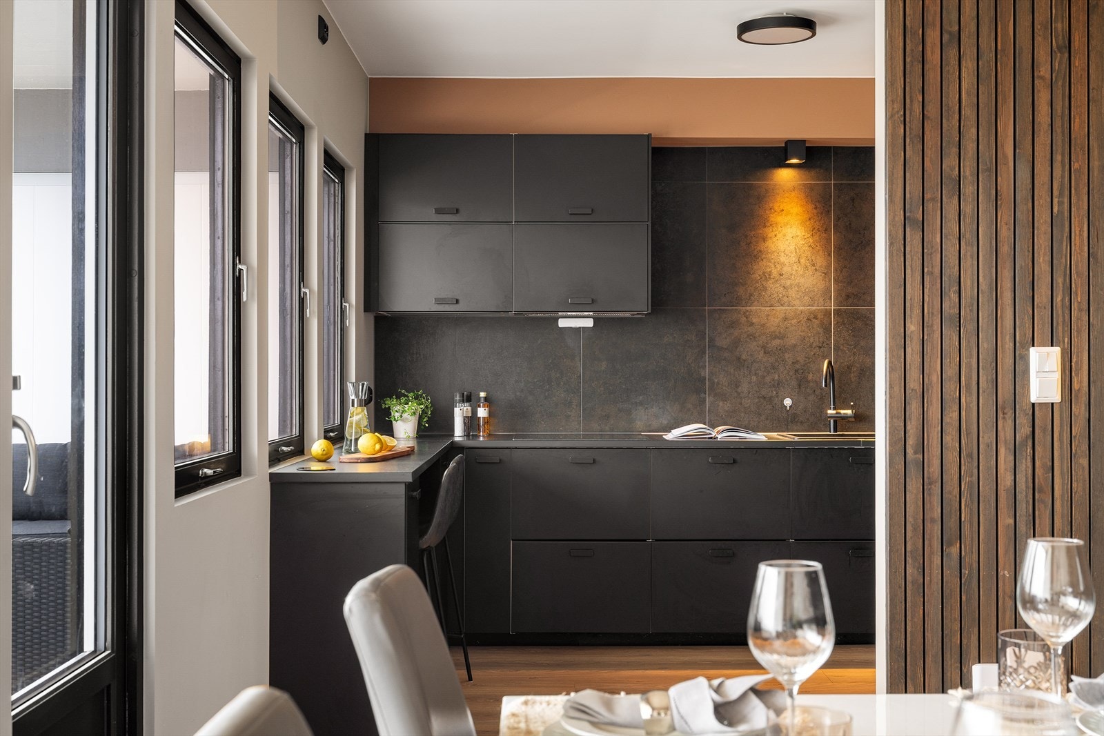 Delvis åpen kjøkkenløsning som gir en naturlig og sosial overgang mot stue og spiseplass Galleribilde