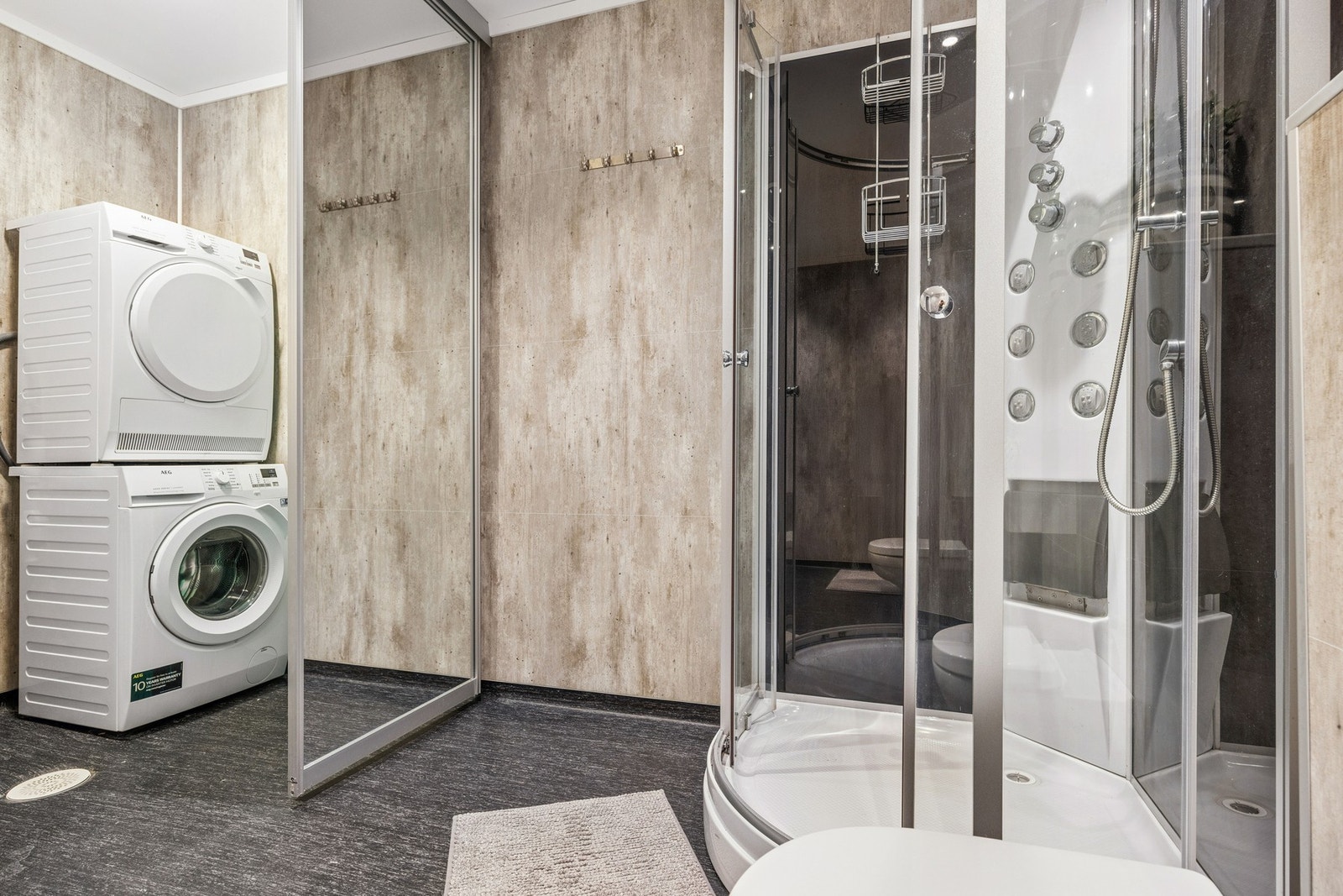 Praktisk løsning med skyvedør mellom bad og opplegg for vaskemaskin Galleribilde