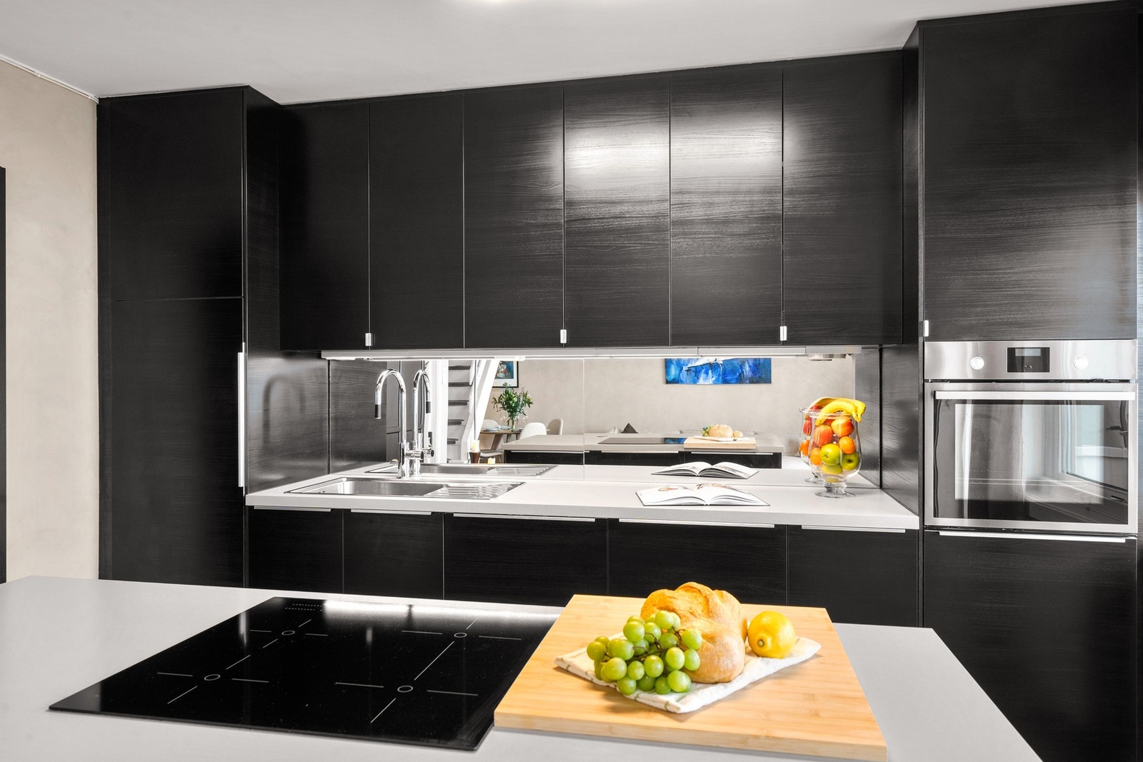 Integrerte hvitevarer med induksjonstopp, stekeovn, oppvaskmaskin og kjøle fryseskap. Komfyrvakt og lekkasjesikring med sensorer gir ekstra trygghet, og belysning under overskap gir godt arbeidslys. Galleribilde