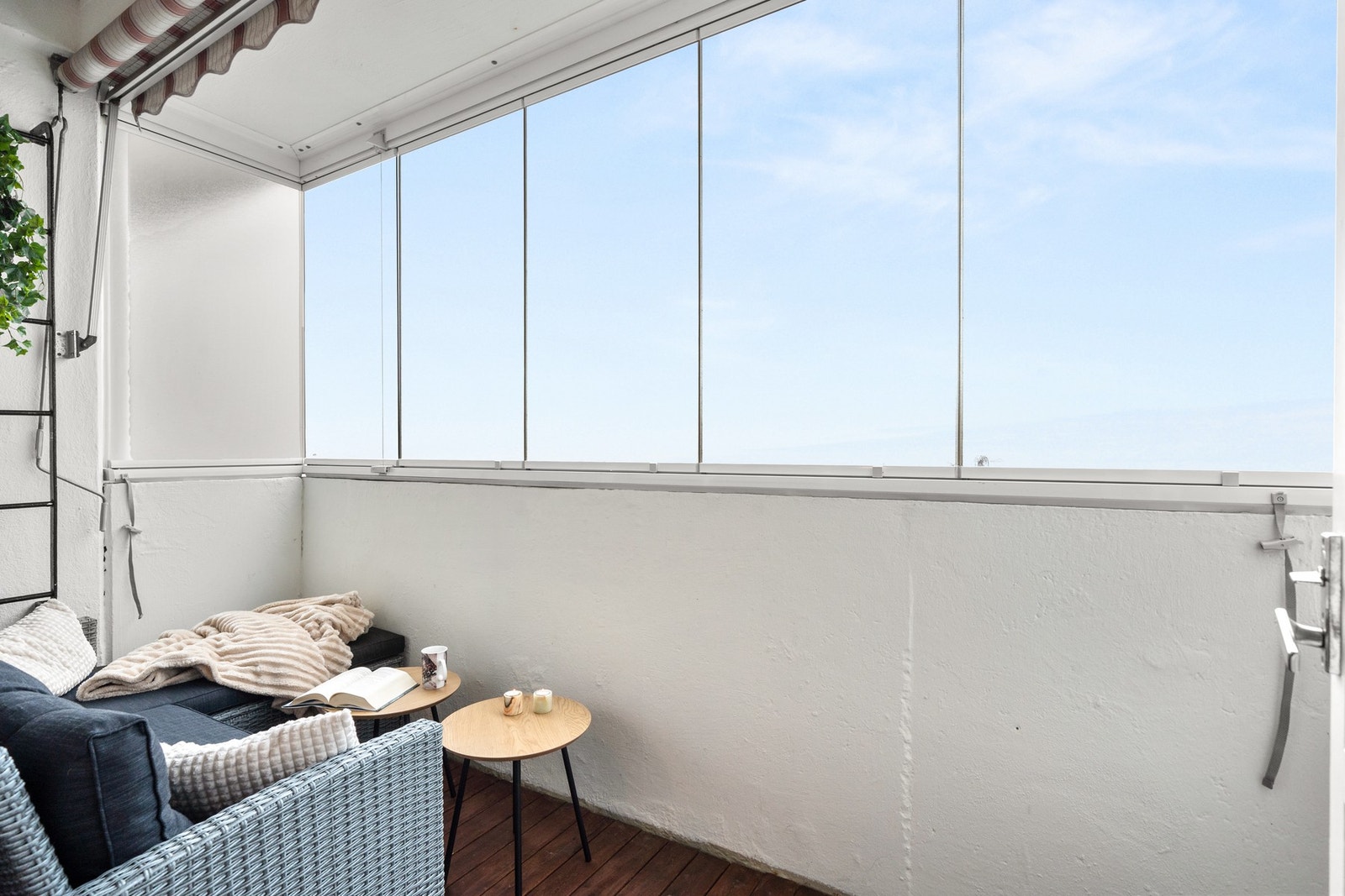 Balkongen er utstyrt med utelys, stikkontakt og markise. Og pent dekket med beiset treassebord på gulvet. Galleribilde