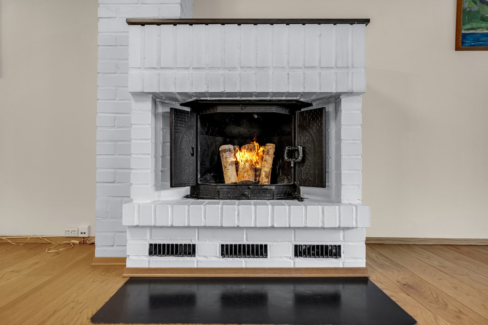 Det er montert peis i stuen, slik at man kan få god varme på de kalde dagene og nyte den herlige atmosfæren som vedfyring gir. Galleribilde