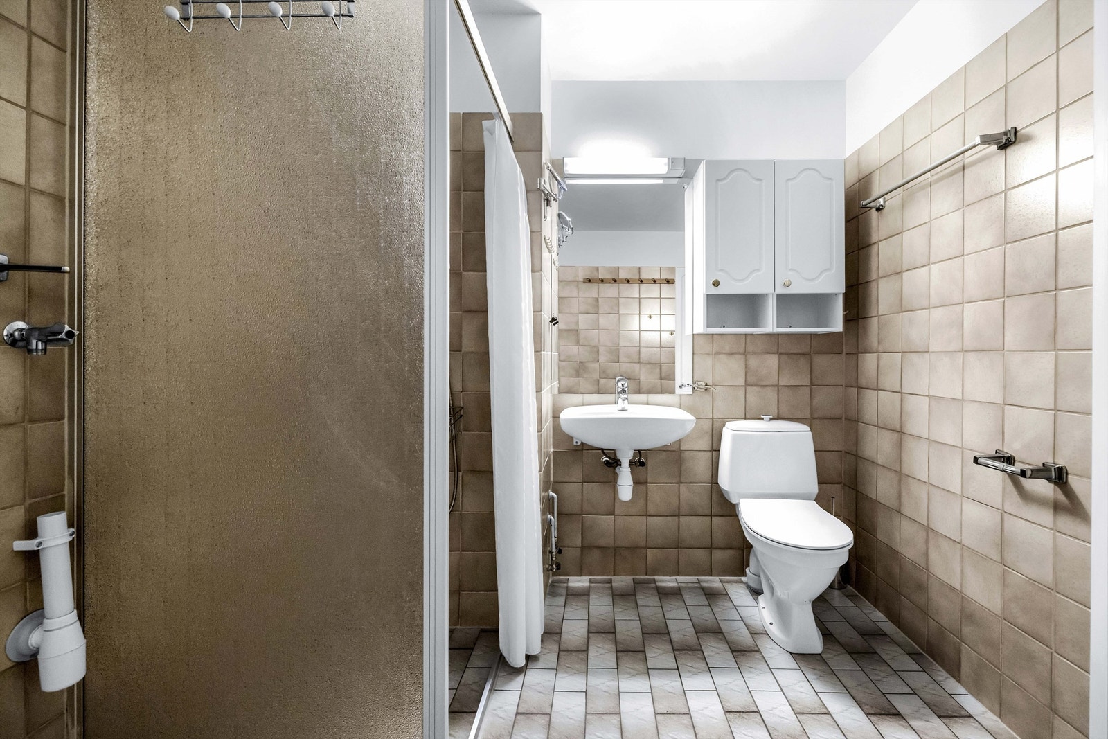 Leiligheten har et romslig flislagt bad med varmekabler. Galleribilde