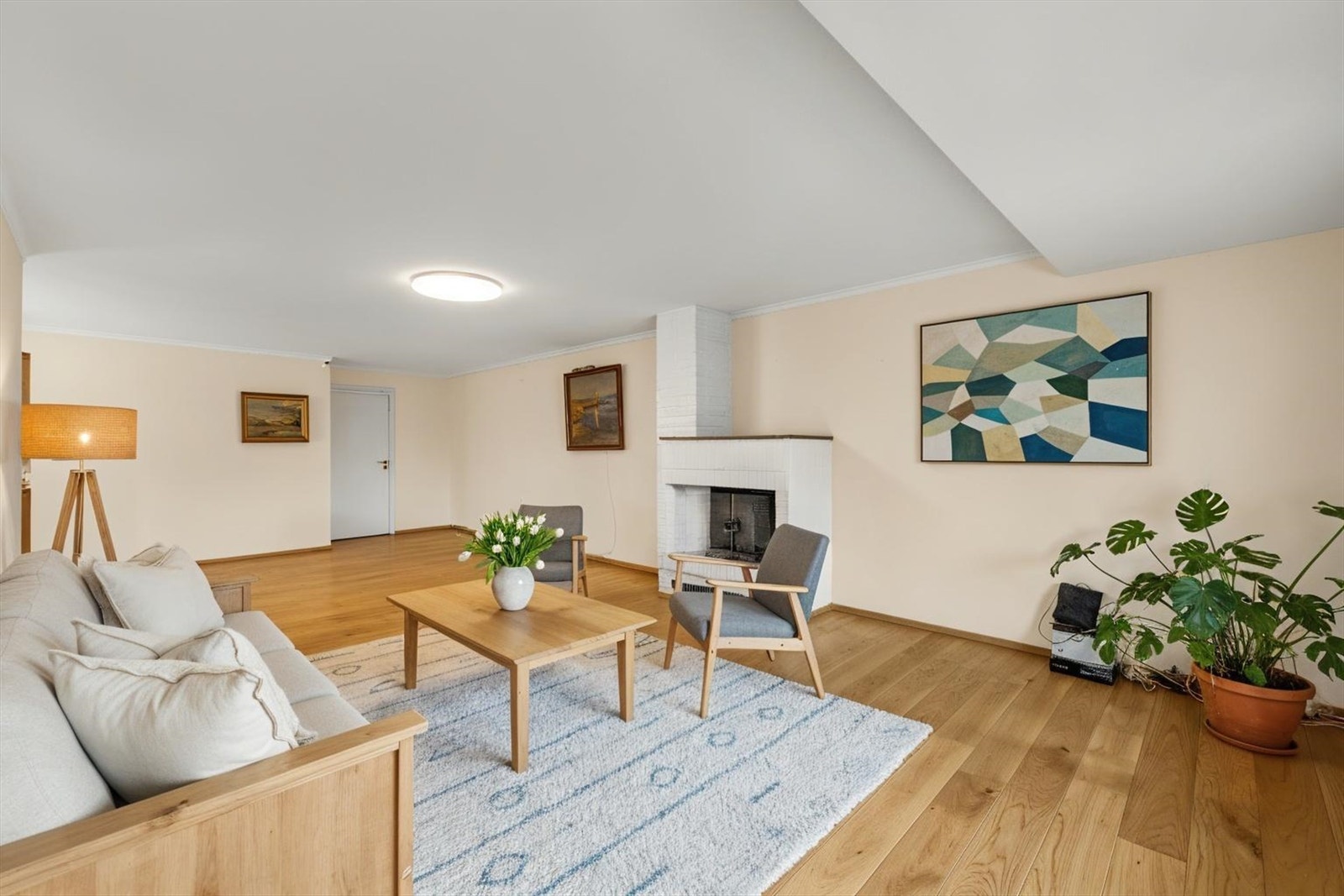 Stuen er romslig og møbleringsvennlig og med en hyggelig peis som varmer opp og skaper hygge på kjøligere dager. Digitalt stylet bilde. Galleribilde