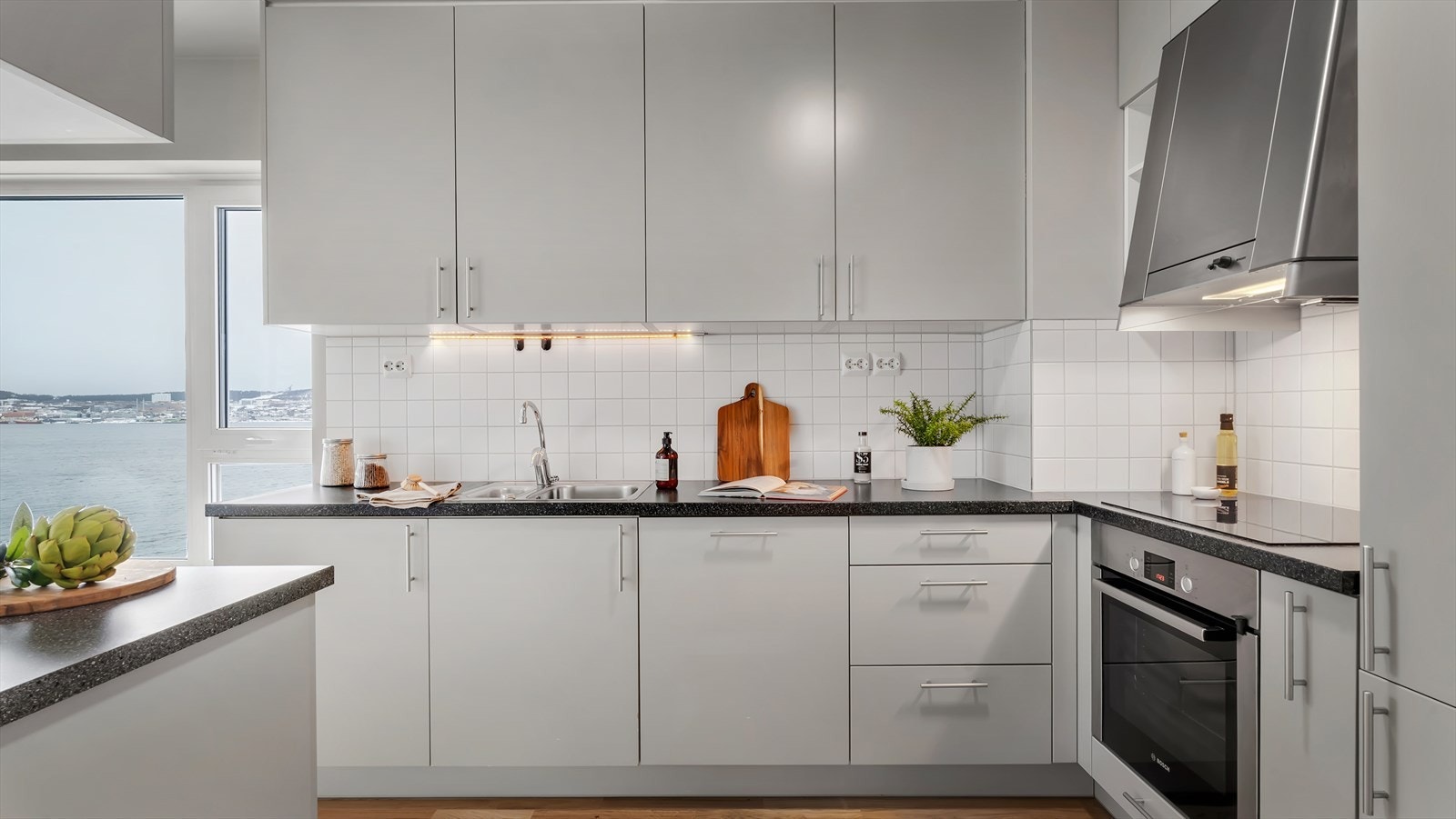 Lyst og tidløst kjøkken med integrerte hvitevarer og rikelig skap- og benkeplass. Galleribilde