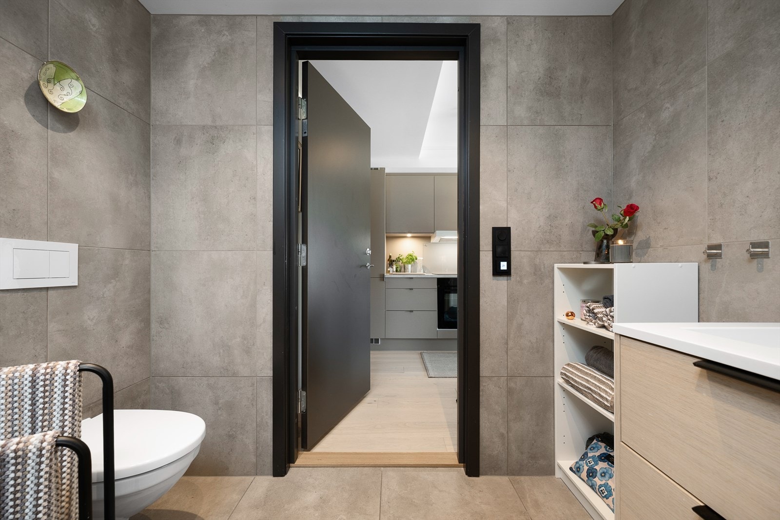 Flislagte tak og vegger. Adkomst til badet fra kjøkkenet. Vegghengt WC. Galleribilde