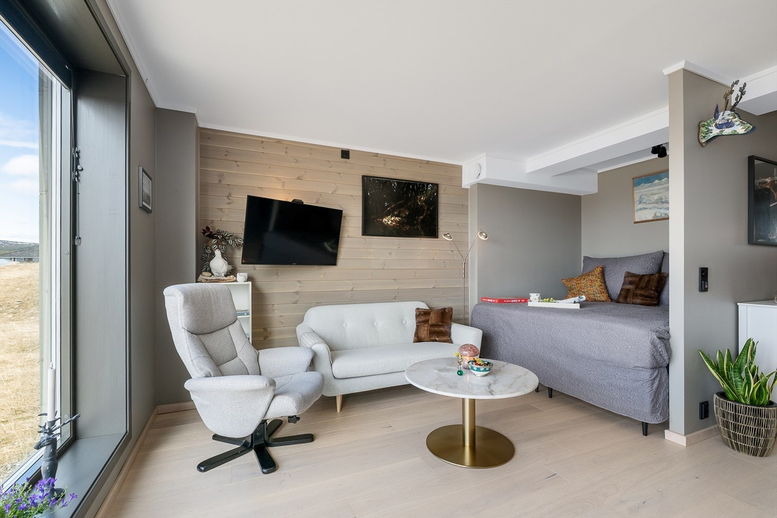 Det er i hovedsak glatte, malte overflater i leiligheten med en kontrastvegg i stua med liggende, beiset panel. Lunt og delikat. Galleribilde