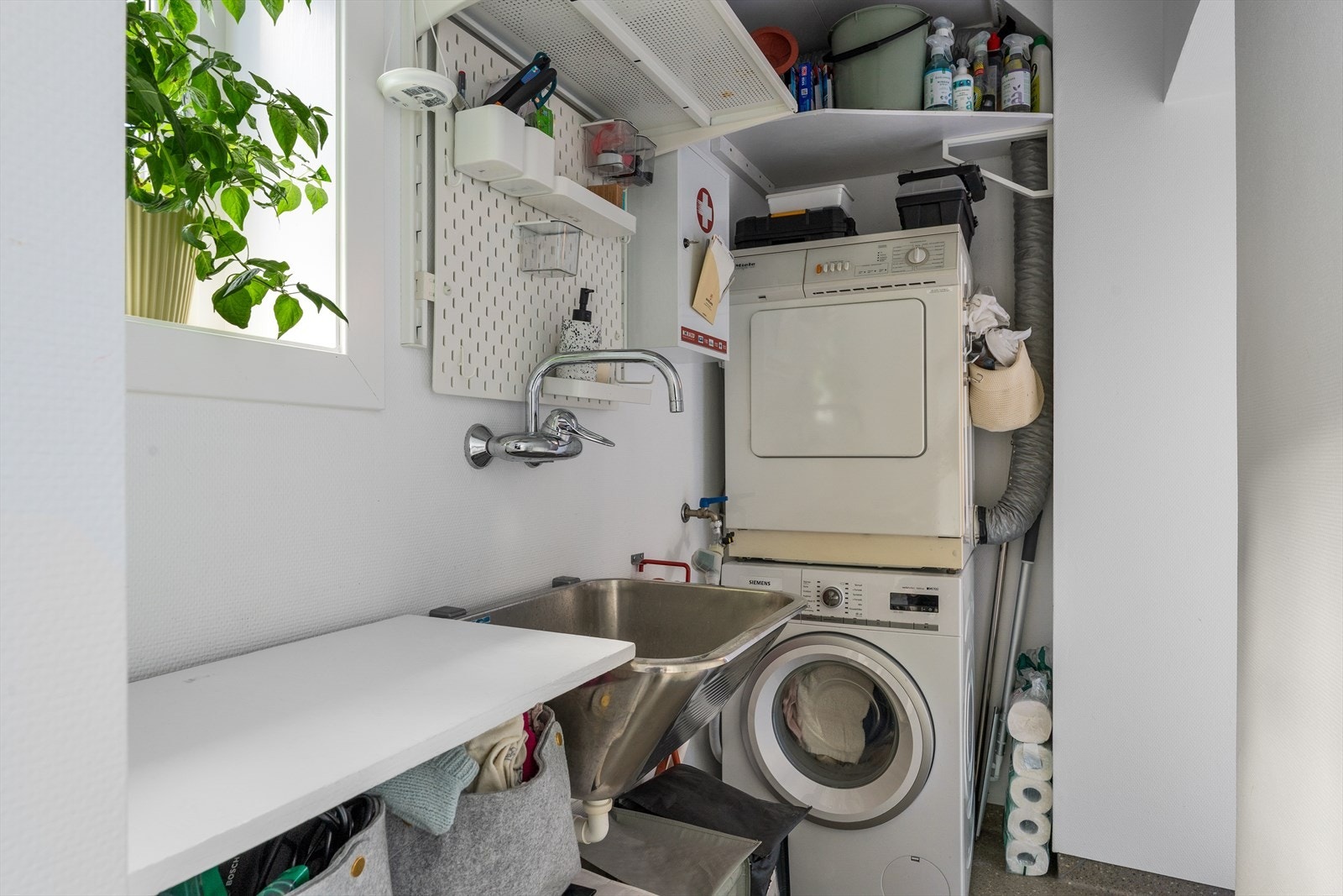 Her er det plass til både vaskemaskin og tørketrommel, i tillegg til utslagsvask og gode oppbevaringsmuligheter. Galleribilde