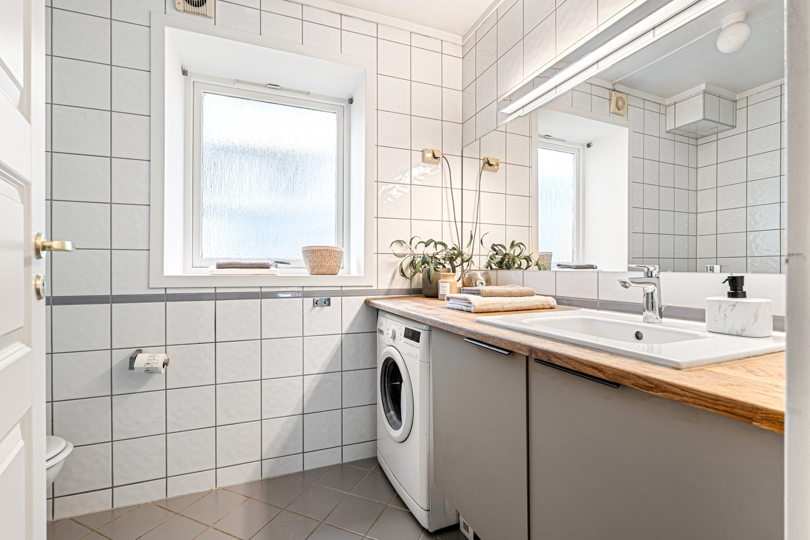 Flislagt bad med god plass til vaskemaskin. Galleribilde