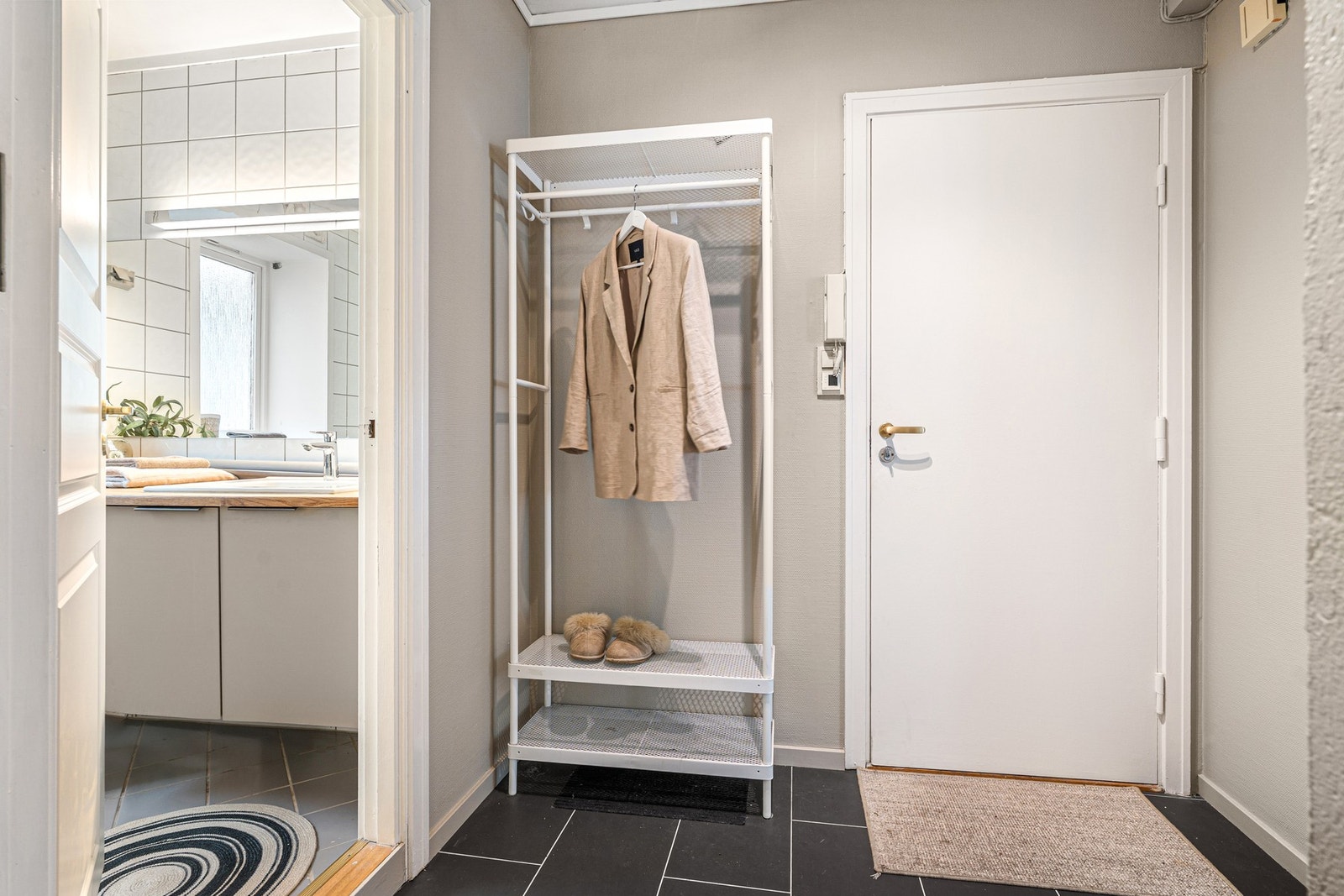 Romslig entre med flis på gulv og god plass til oppheng av klær. Galleribilde