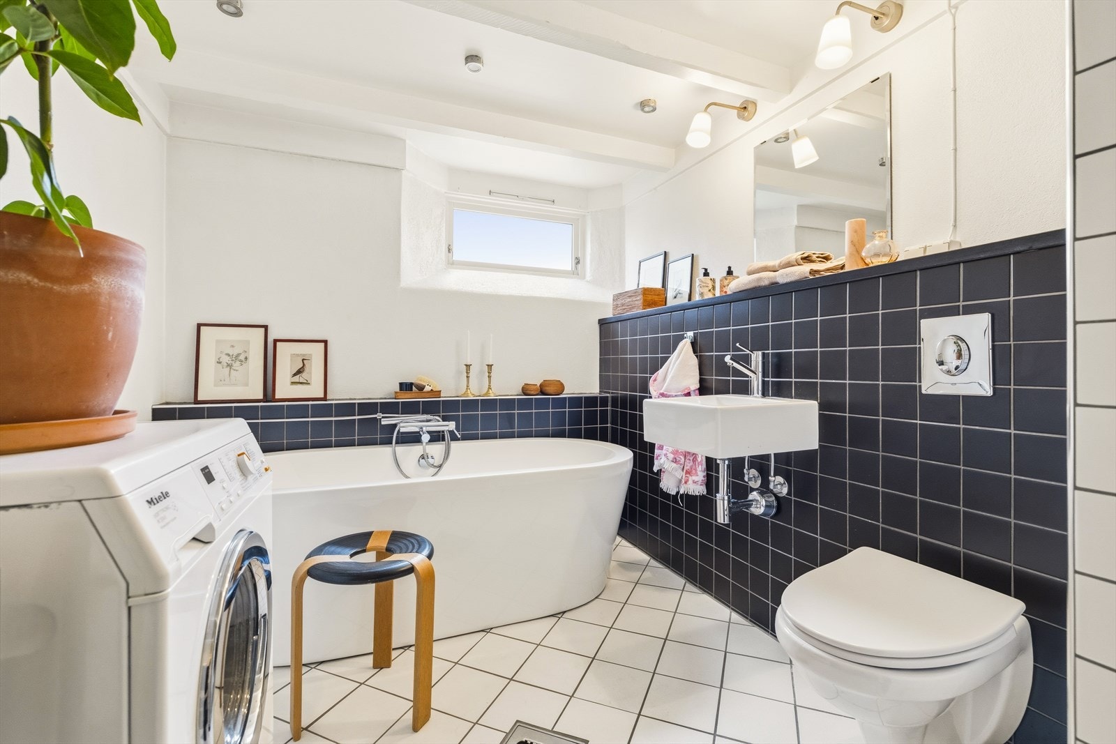 Bad i tilknytning til hybel i kjeller. Detaljer som opplegg for vaskemaskin, badekar, samt dusjnisje Galleribilde