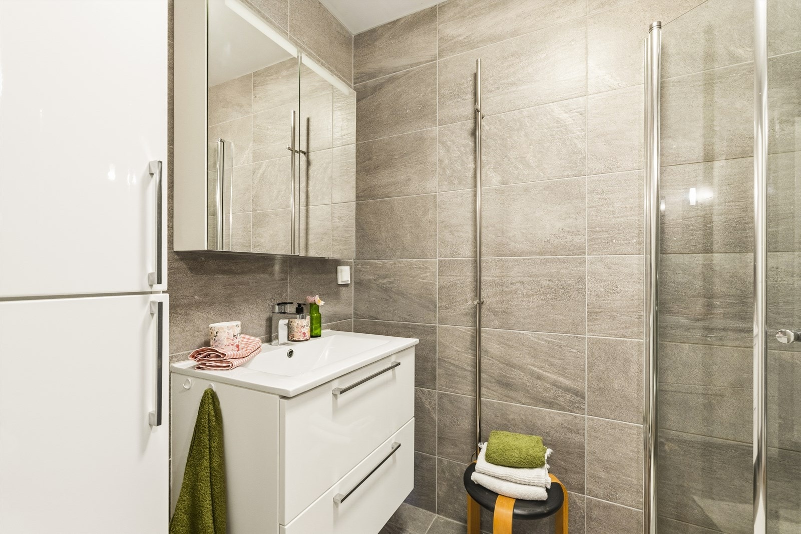 Moderne flislagt bad fra 2013. Skittentøyssjakt i skap går direkte til underliggende vaskerom. Godt med skap og skuffeplass Galleribilde