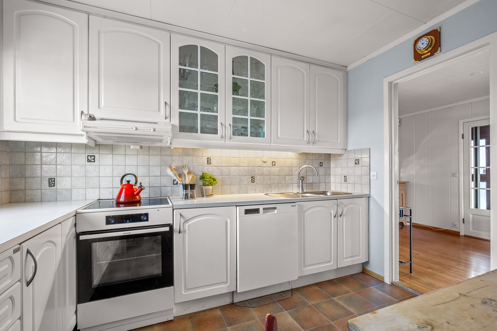 Klassisk kjøkkeninnredning i hvitt med profilerte fronter. Galleribilde