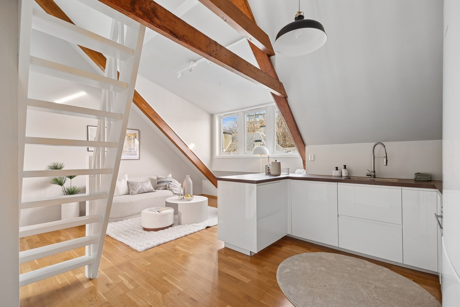 Den mørke benkeplaten spiller elegant mot de mørke takbjelkene, og skaper et gjennomført og harmonisk uttrykk i rommet. Galleribilde