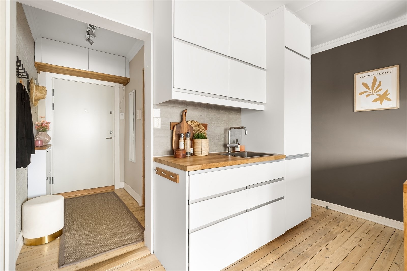 Kjøkkeninnredning med hvite, glatte fronter og benkeplate i tre. Benkeplaten og servanten ble byttet i 2023. Galleribilde