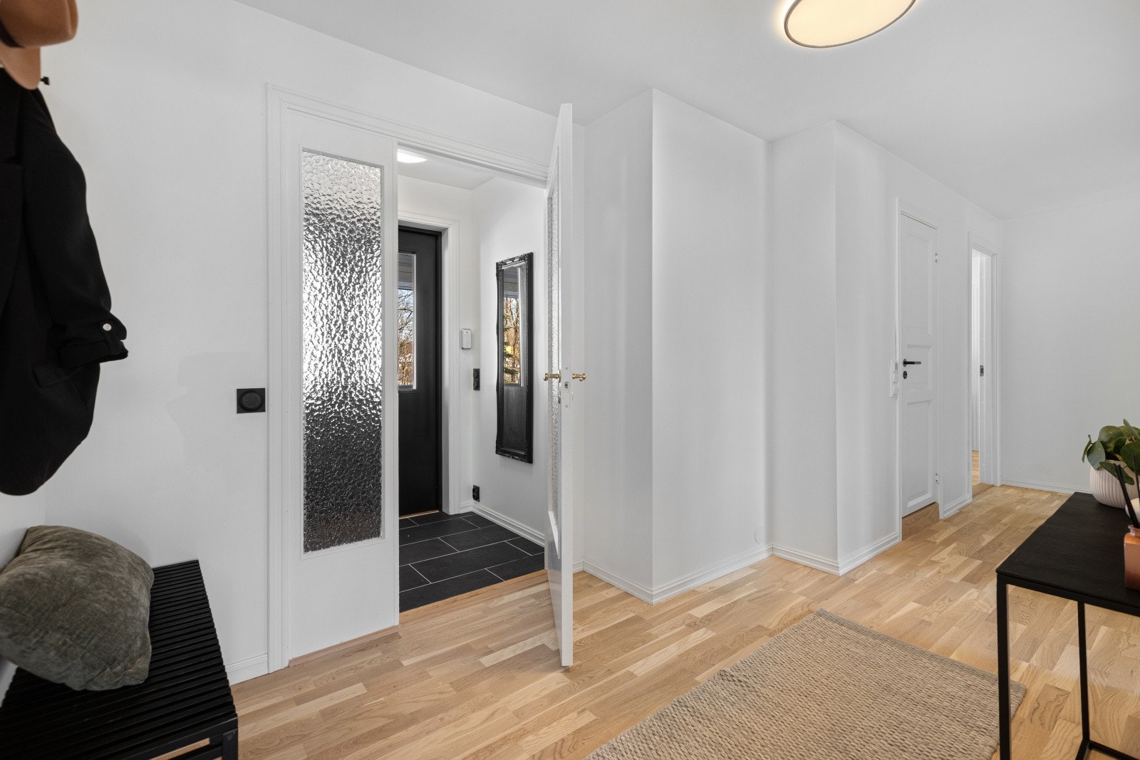 Entréen har flislagt gulv og hvitmalte vegger som gir et lyst og innbydende førsteinntrykk. Videre kommer du til en romslig hall med god plass til oppbevaring av yttertøy og sko for hele familien. Galleribilde