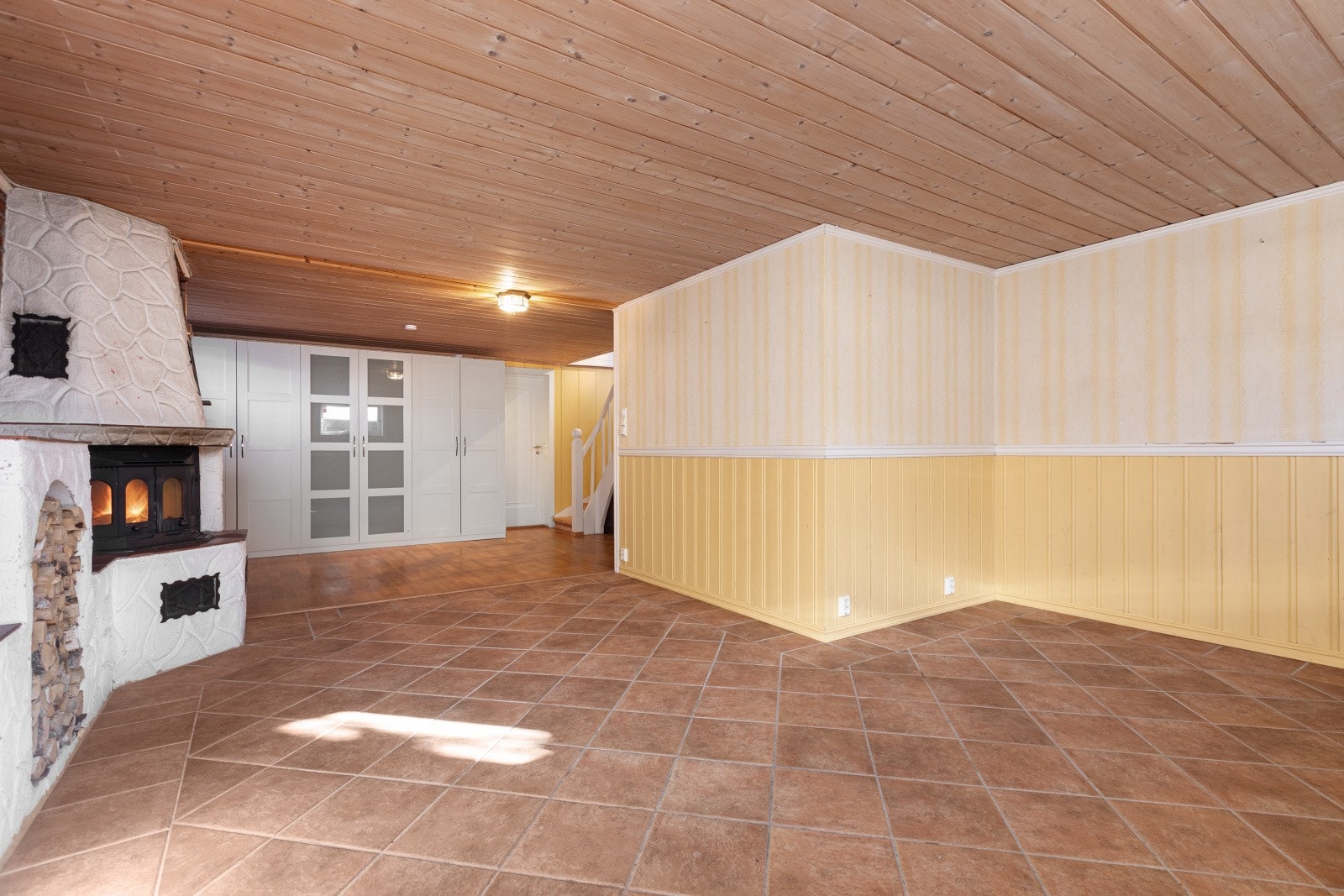 Den koselige kjellerstuen har varmekabler i gulvet og peis som bidrar til behagelig oppvarming. Galleribilde