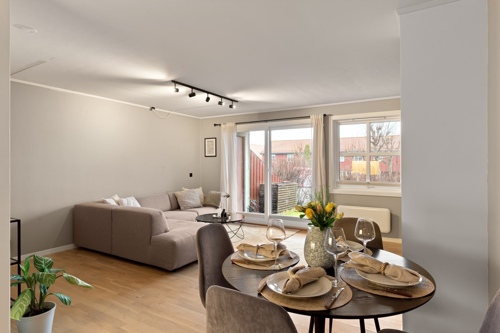 Stue- og kjøkken i en halvveis åpen løsning som skaper et sosialt allrom Galleribilde