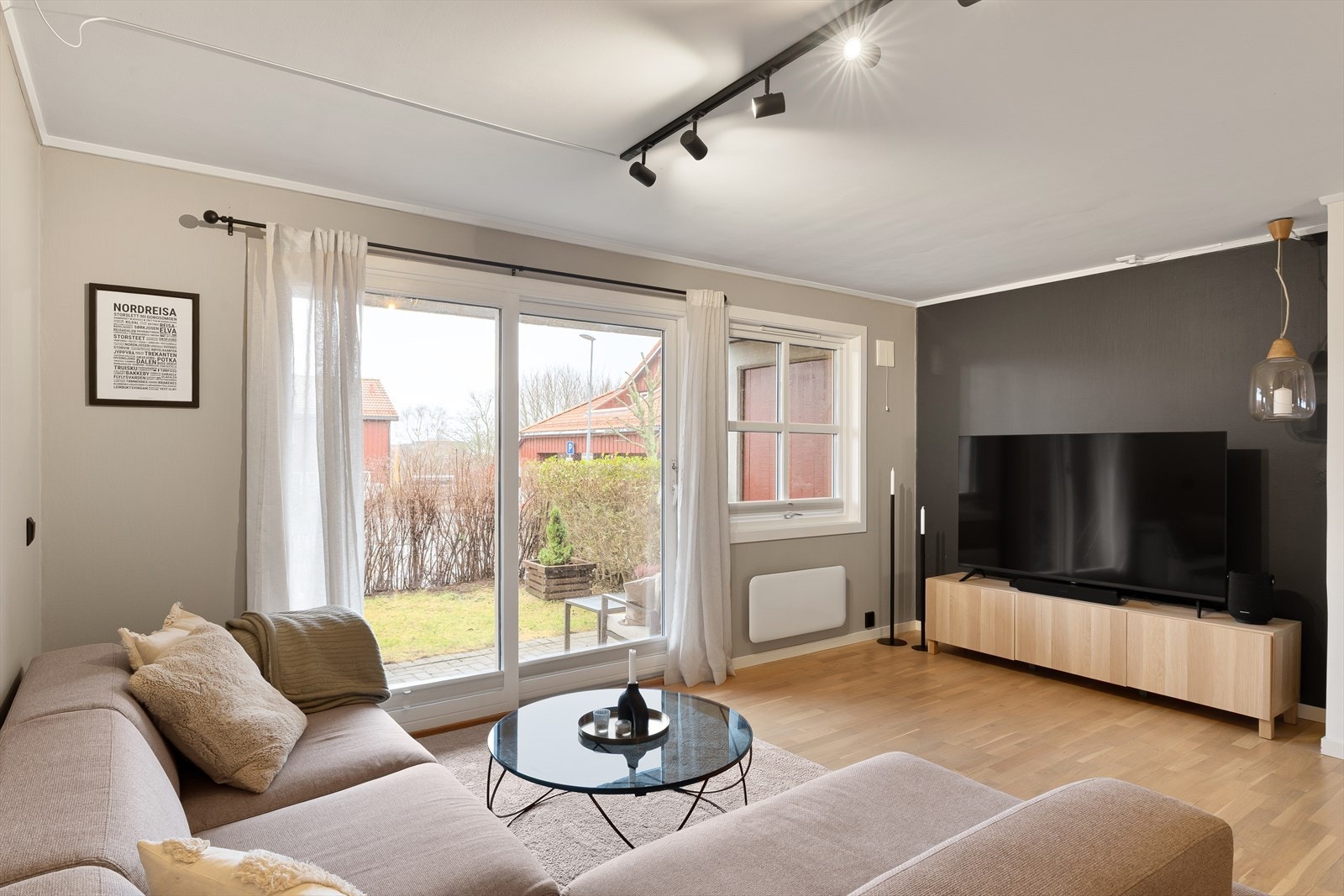 Stue med parkett på gulv og gode vindusflater som gir rikelig med naturlig lys Galleribilde