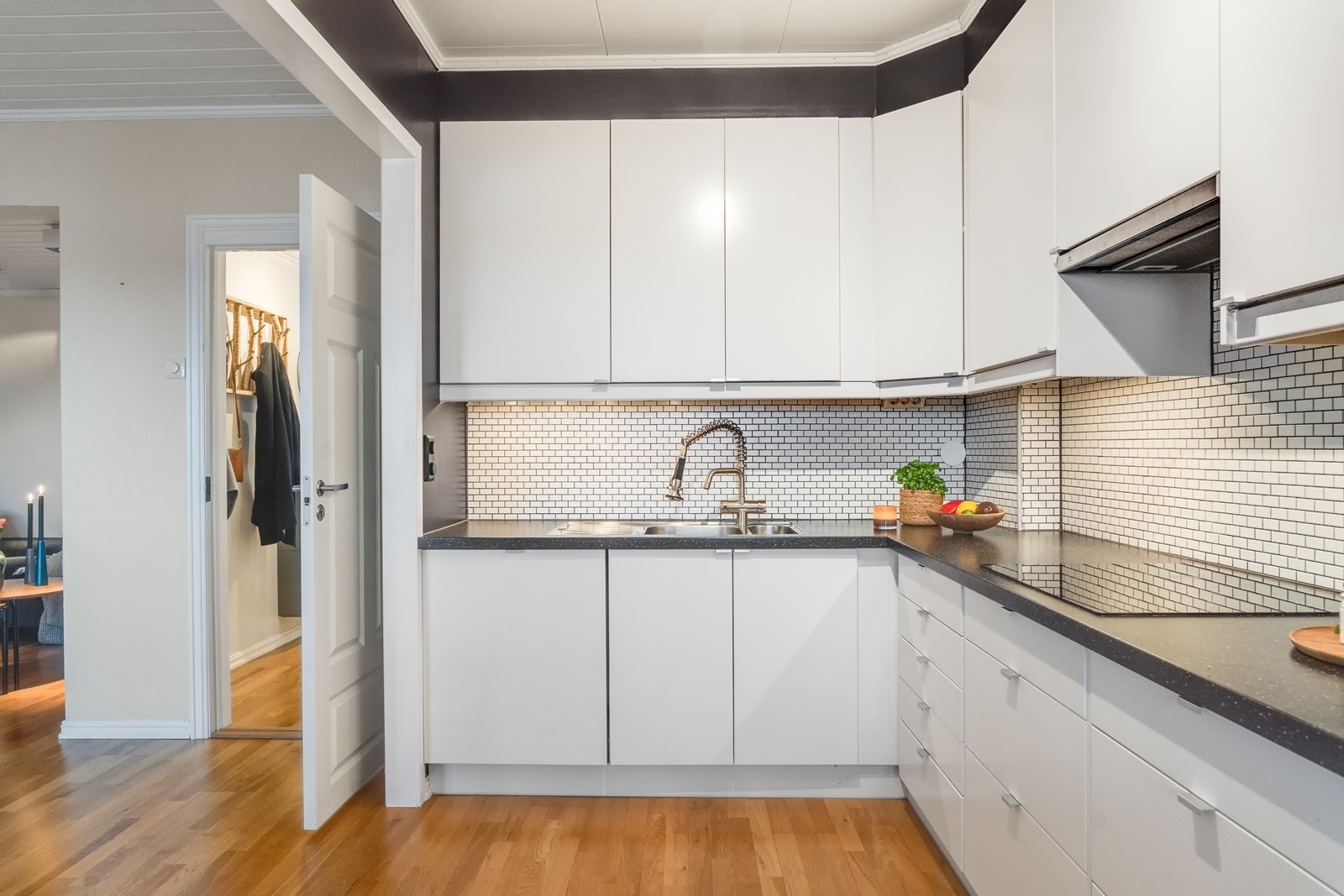 Flott kjøkkeninnredning som er lys og moderne, utført med slette hvite fronter og benkeplate av laminat. Galleribilde