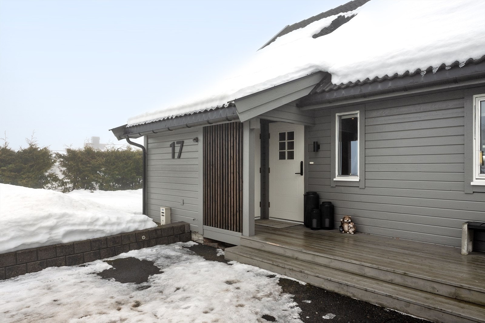 Nyere overbygget inngangsparti med terrasse og sitteplass Galleribilde