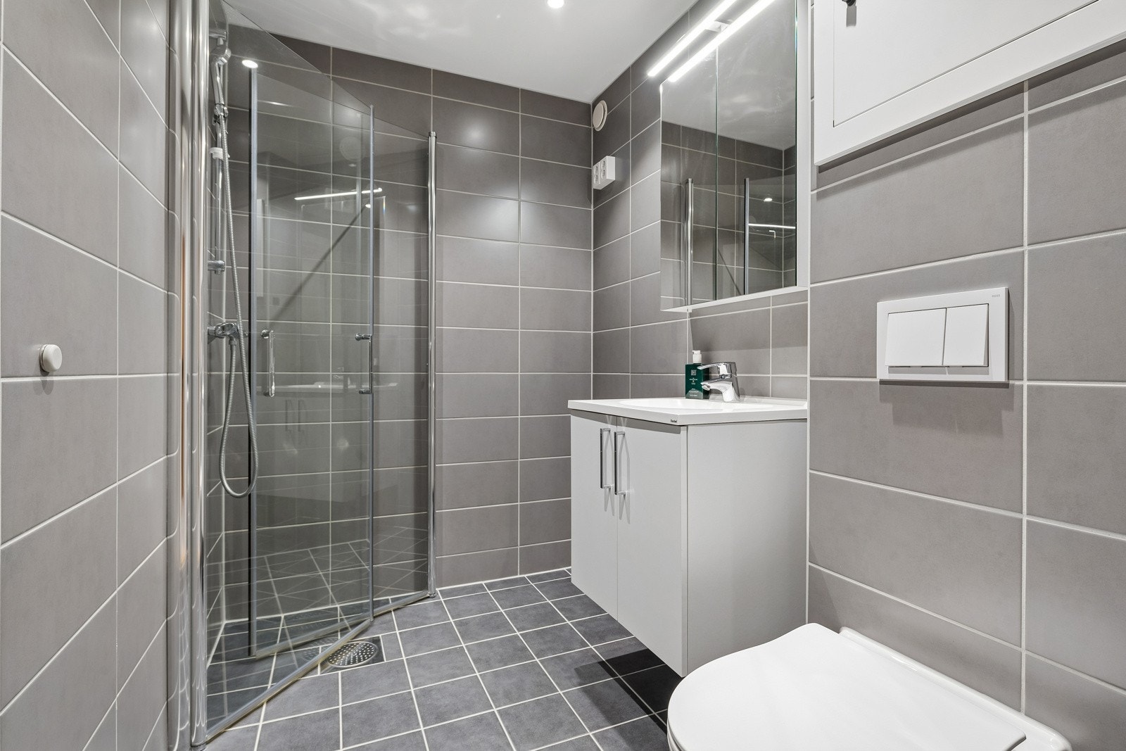 Rehailitert bad i regi av brl., ferdigstilt i 2023. Moderne servant med innredning, vegghengt toalett, dusj med skyvglass. Galleribilde