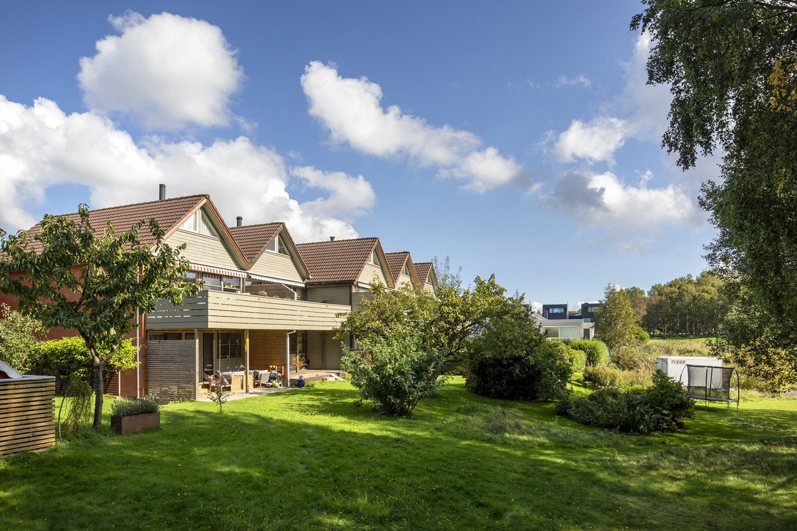 Hagen grenser mot et felles grøntområde, noe som gir en åpen og parkmessig følelse. Galleribilde