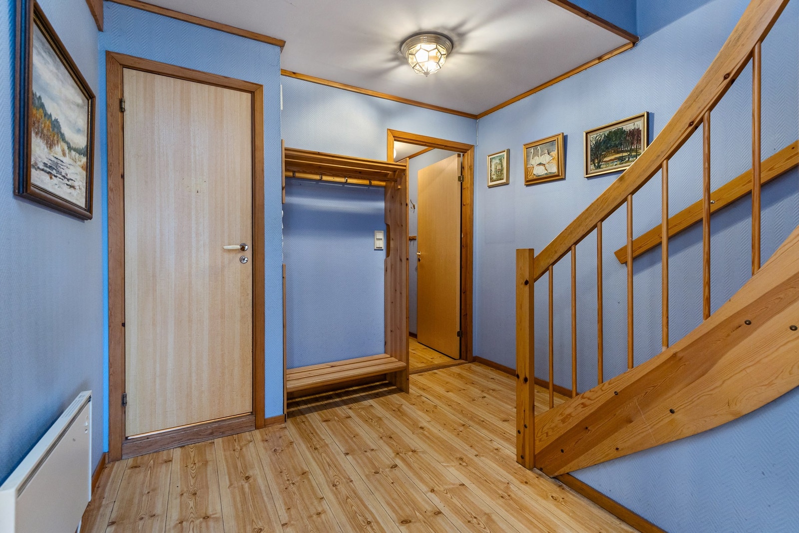 Entréen har plass til oppbevaring av yttertøy og sko. Trappen i tre binder etasjene sammen. Galleribilde