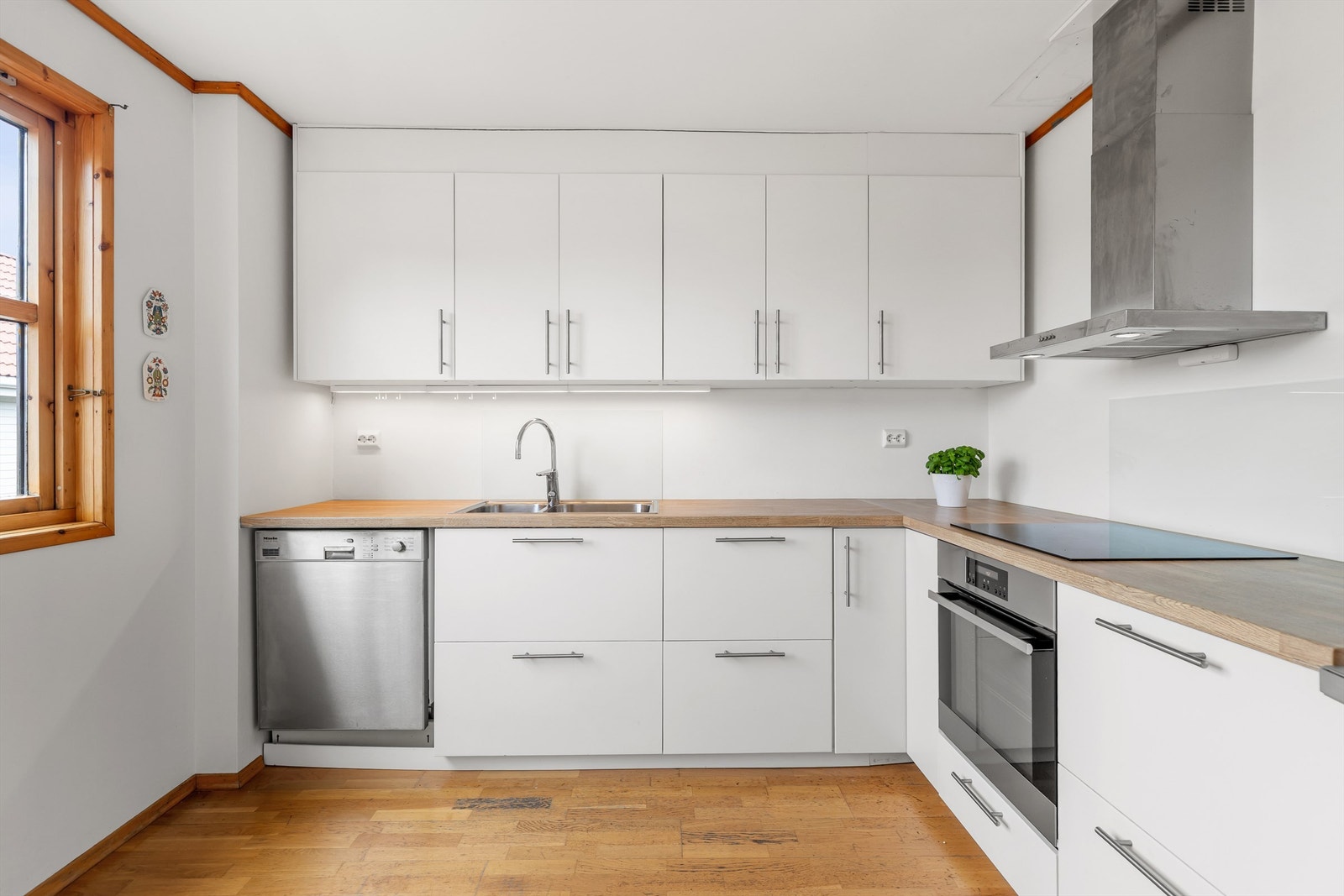 Kjøkkeninnredning med slette fronter og rikelig med lagringsplass. Galleribilde