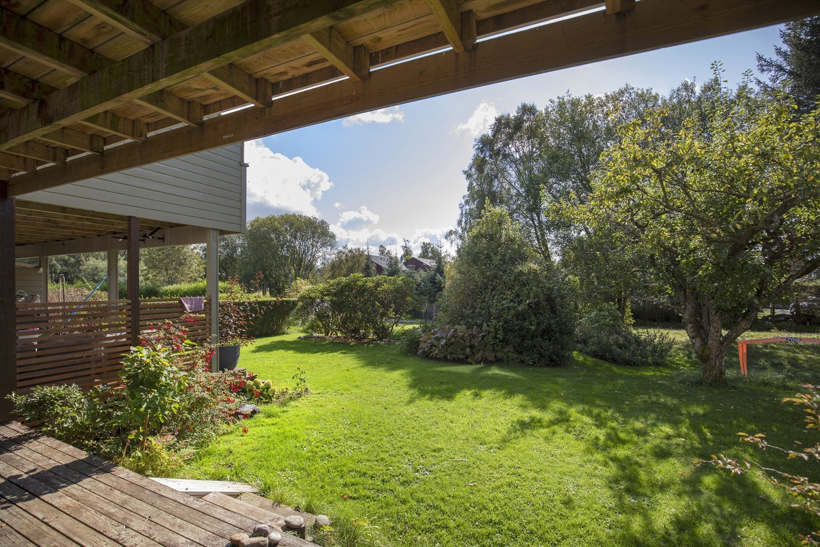 Utsikt fra terrassen over den frodige hagen. Galleribilde