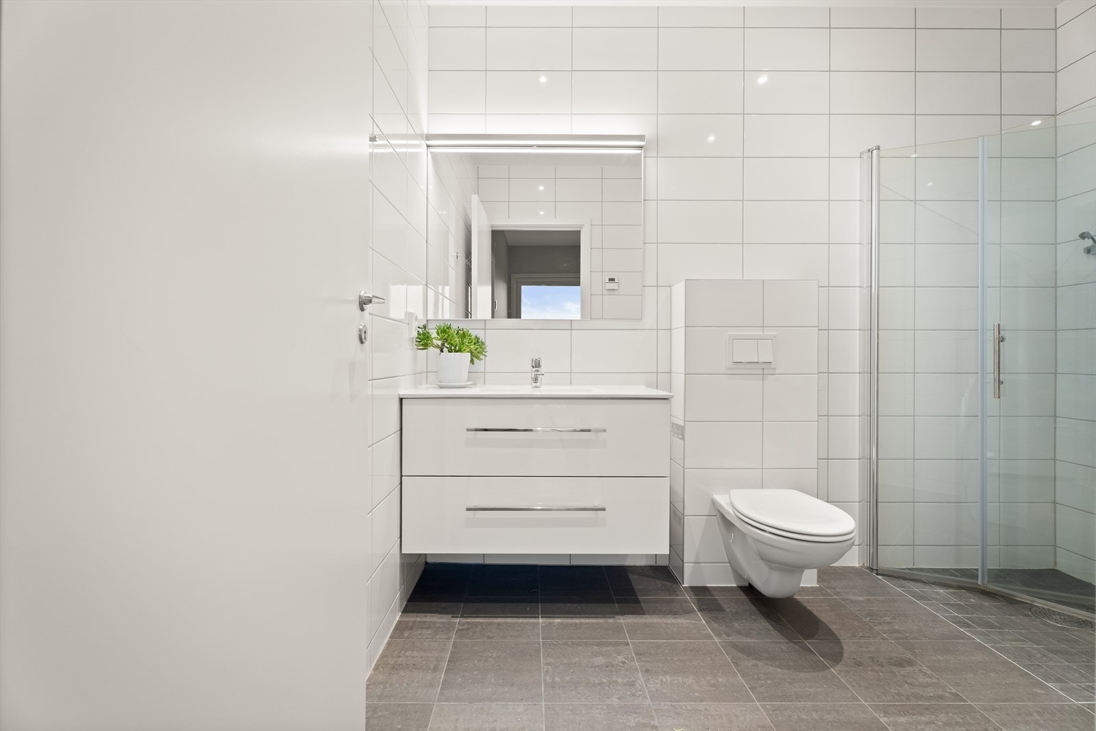 Badet har servantinnredning med god oppbevaringsplass og vegghengt toalett. Galleribilde