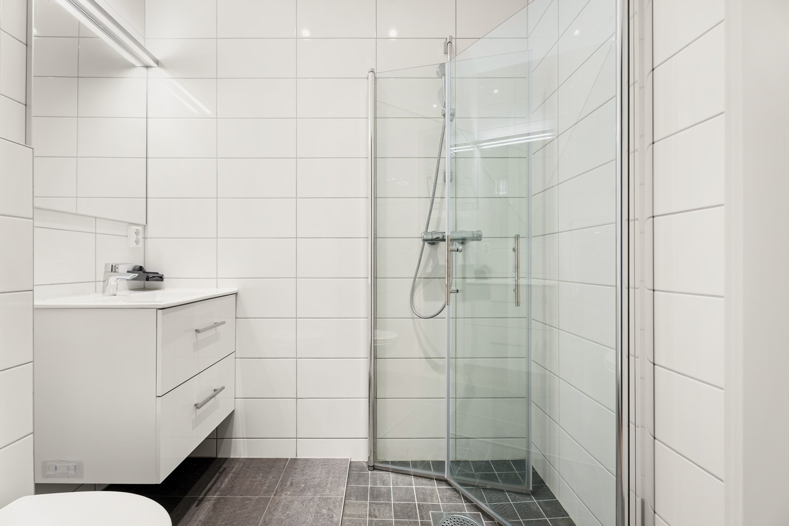 Det andre badet har adkomst fra hovedsoverommet, med fliser, dusjhjørne og vegghengt toalett. Galleribilde