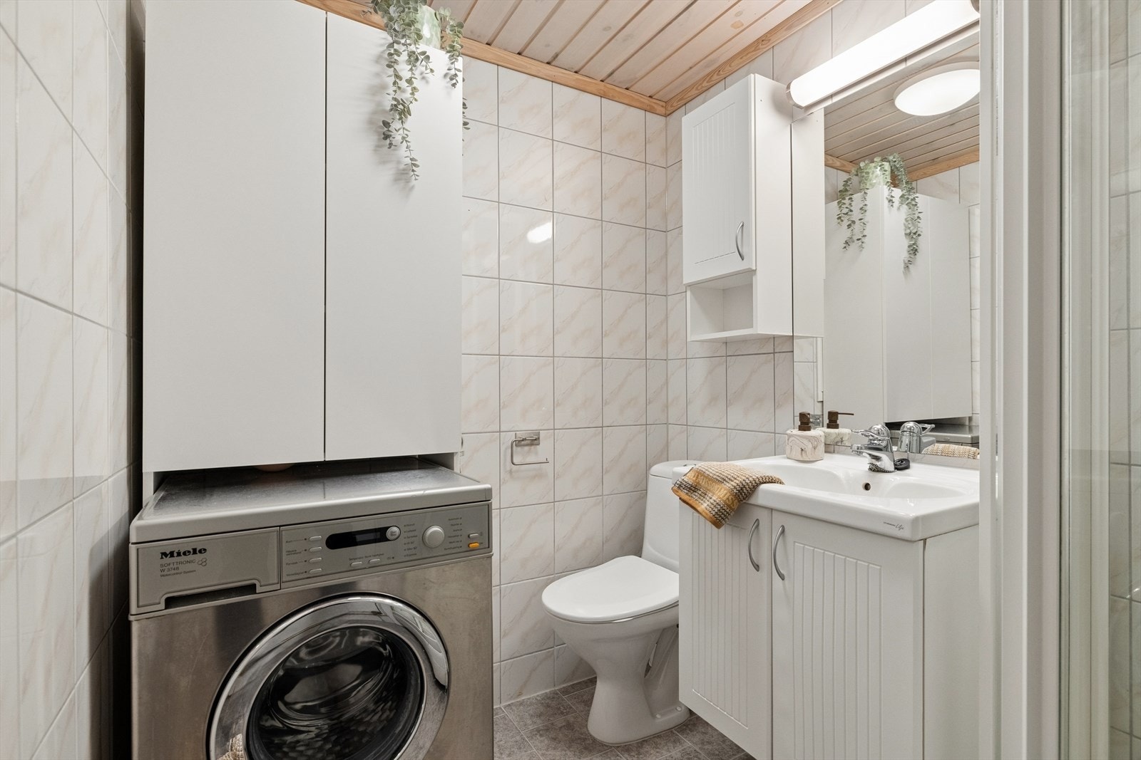 Badet er fra 2006 og er innredet med grå fliser på gulvet og lyse, sjatterte fliser på vegg. I gulvet har man også varmekabler for ekstra komfort. Galleribilde