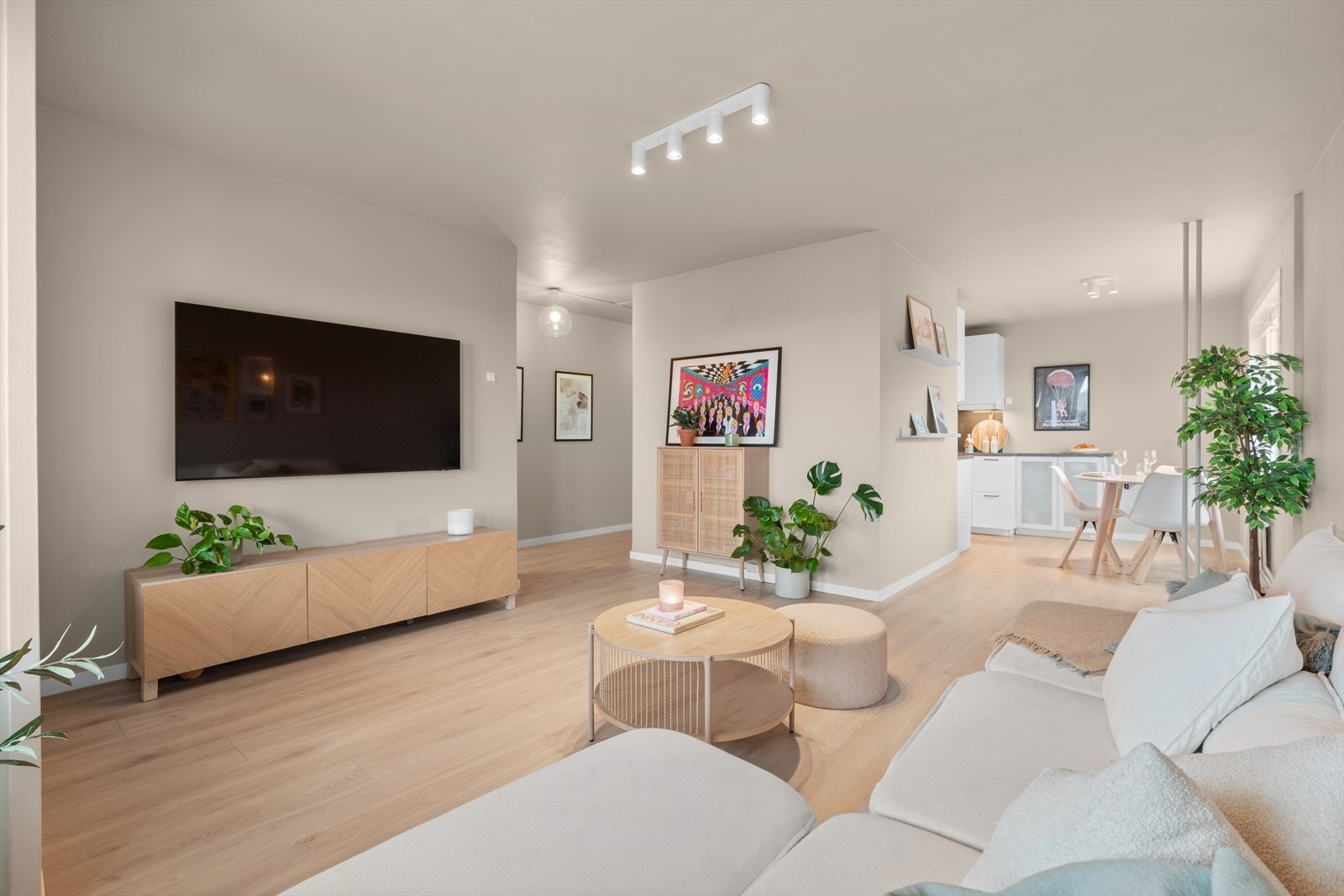 Stuen fremstår lys, romslig og moderne med en rolig og harmonisk fargepalett. Veggene er malt i lyse, varme toner som sammen med det lyse parkettgulvet skaper en luftig og innbydende atmosfære. Galleribilde
