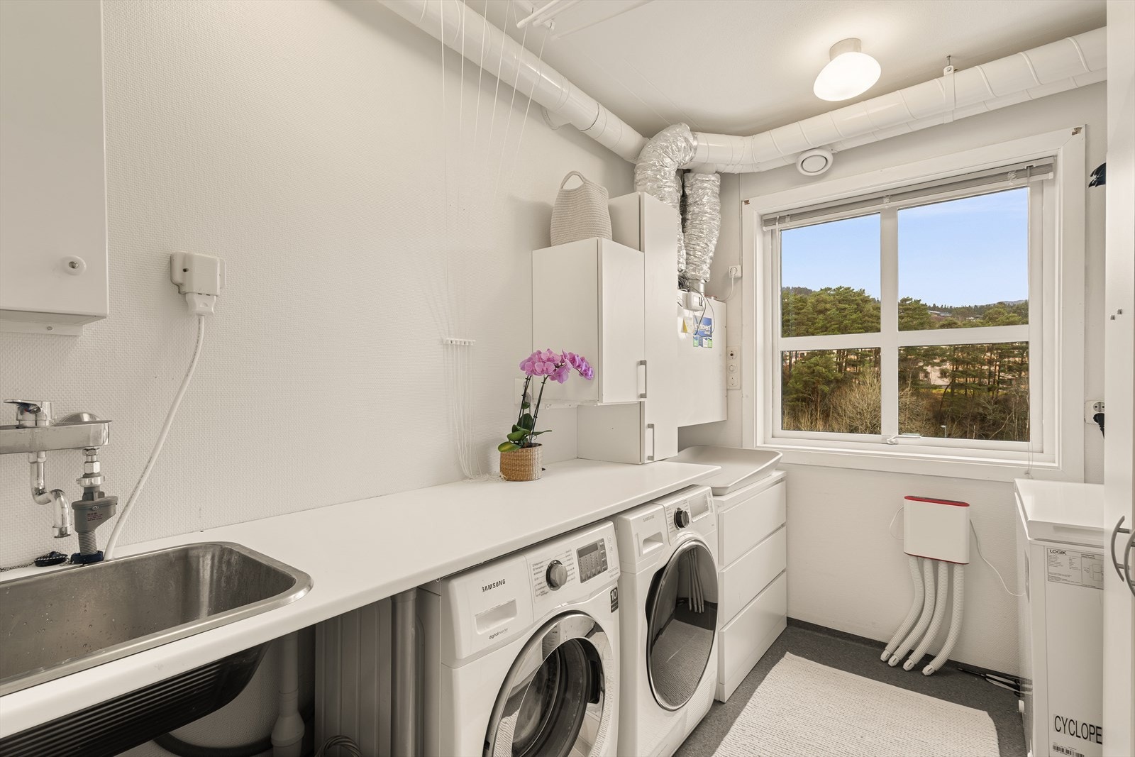 Vaskerommet har vinylbelegg på gulvet og er utstyrt med nedfelt utslagsvask i benkeplate. Aggregatet for balansert ventilasjon er plassert i rommet. Galleribilde