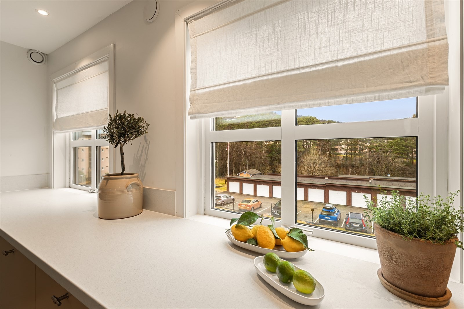 Store vinduer gir naturlig lys og utsikt mot nærområdet og parkeringsplass. Galleribilde