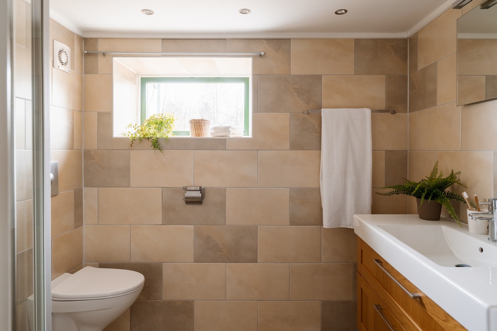 Badet i 1. etasje er flislagt og utstyrt med dusjnisje, servant med underskap og vegghengt toalett. Galleribilde