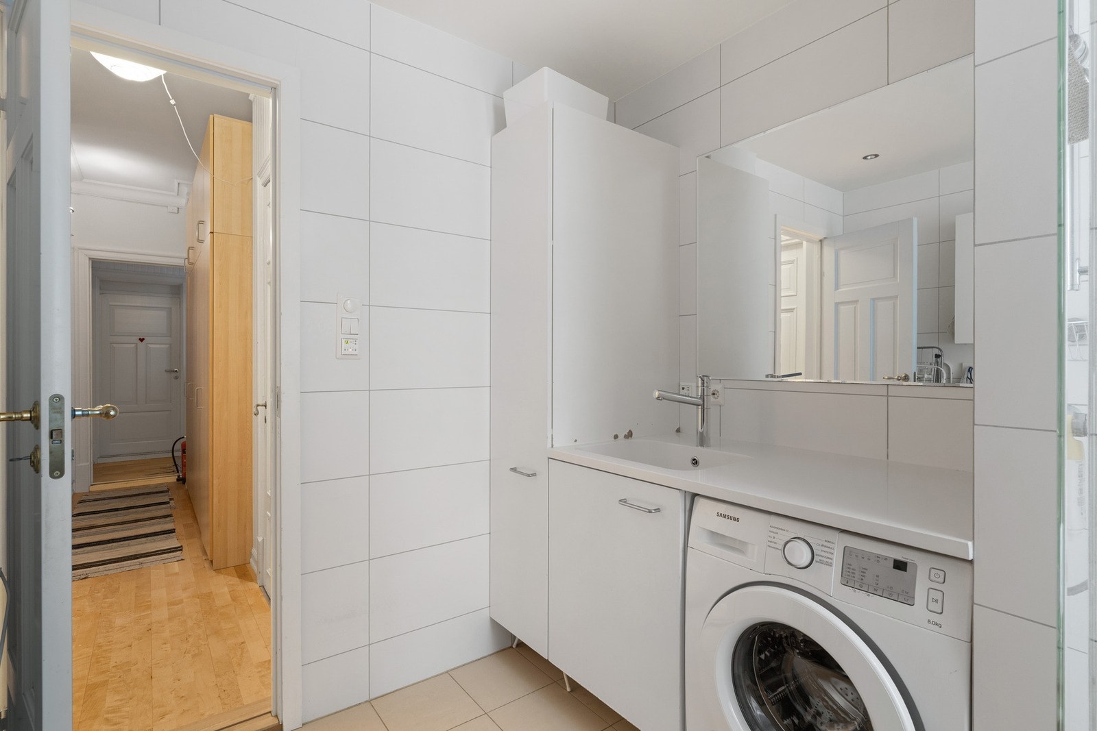 Innredet med dusjnisje, vegghengt servantskap med nedfelt servant, og opplegg for vaskemaskin. Galleribilde