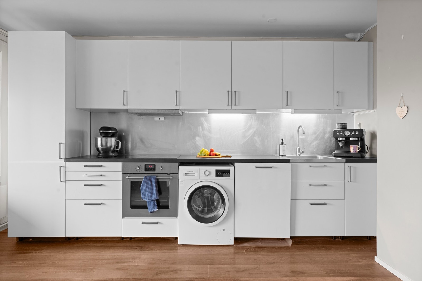 Innredningen er hvit laminert med trebenkeplate, ettgreps blandebatteri, integrert kjøl/frys, oppvaskmaskin og vaskemaskin Galleribilde