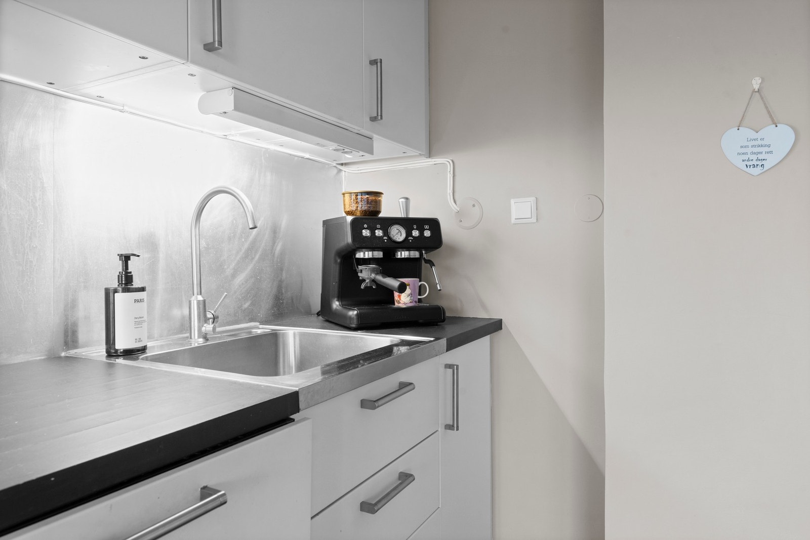 Mellom over- og underskap er det satt opp backsplash, og belysning under overskapene gir både funksjon og atmosfære Galleribilde