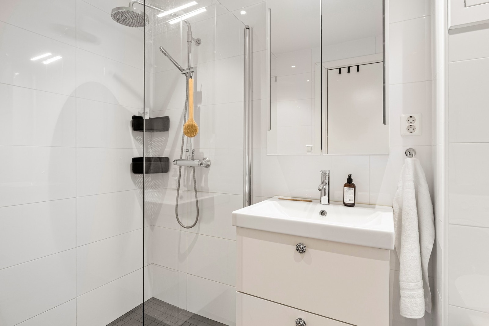 Det er innredet med vegghengt toalett, dusjgarnityr i dusjhjørne og baderomsmøblement med speil og belysning. Galleribilde