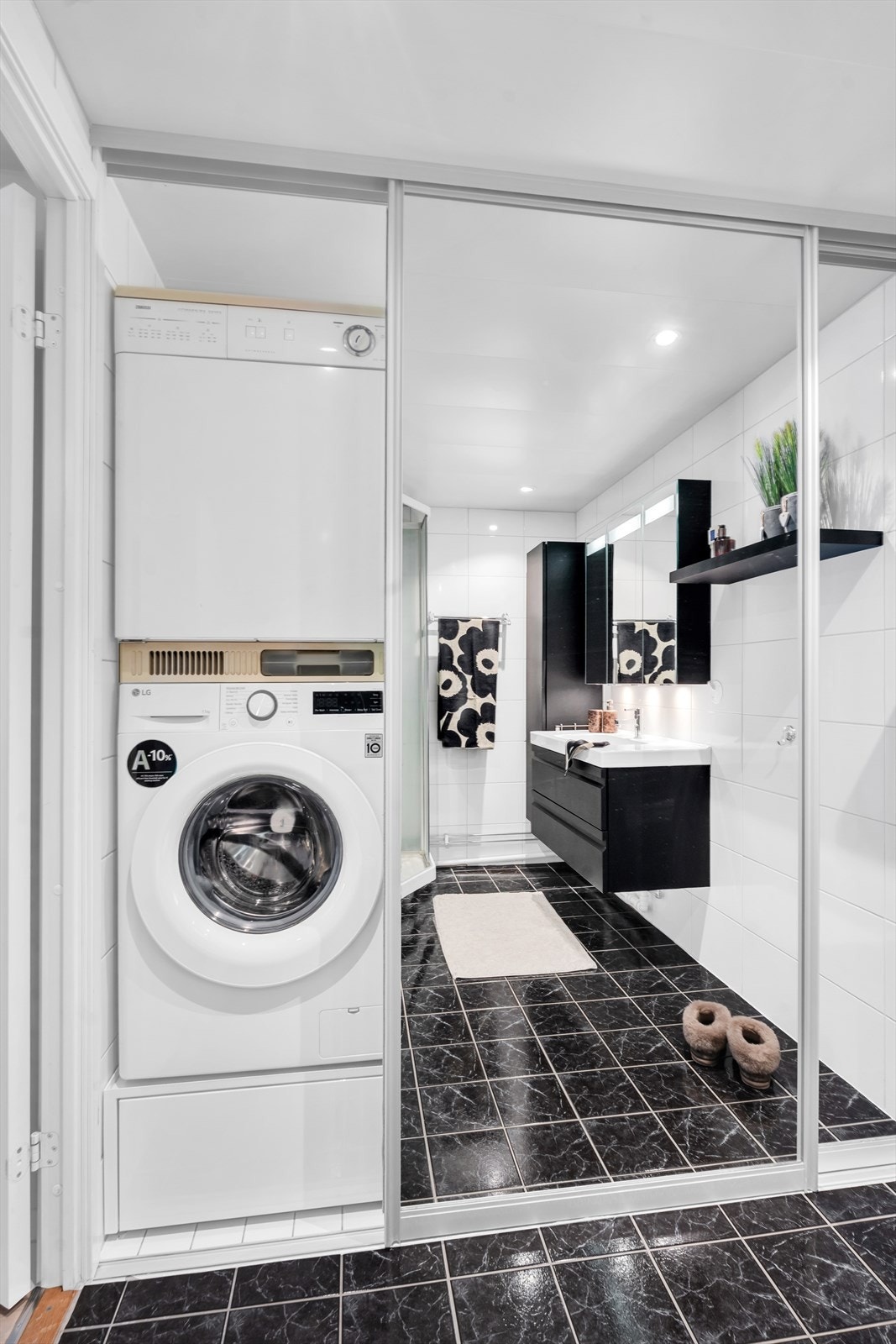 Meget praktisk skyvedørsløsning på badet skjuler vaskemaskin og tørketrommel, samt gir ekstra lagringsplass. Galleribilde