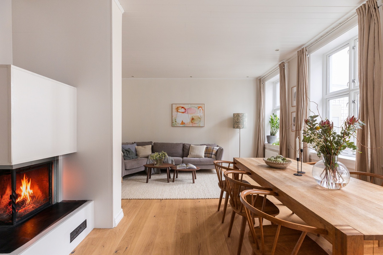 Den åpne peisen er elegant integrert i veggen og tilfører rommet både varme og karakter. Galleribilde