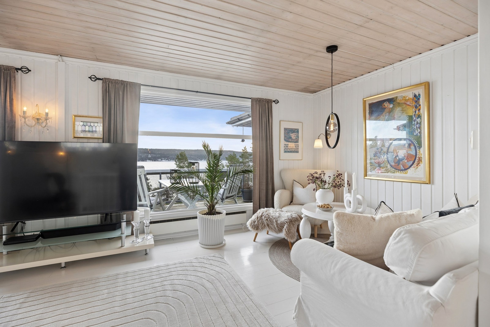 Lys og innbydende stue med store vinduer mot utsikten. Galleribilde